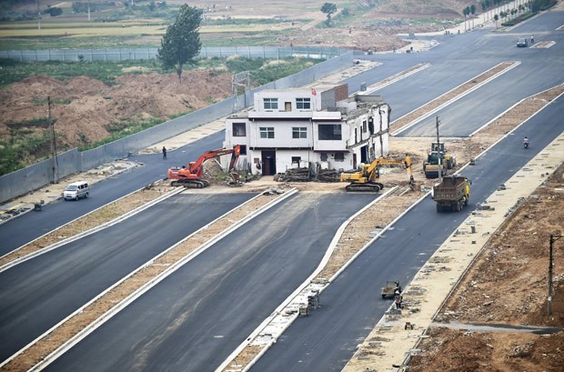 Prédio foi deixado no meio de estrada recém-construída na China (Foto: Reuters) casa-estrada
