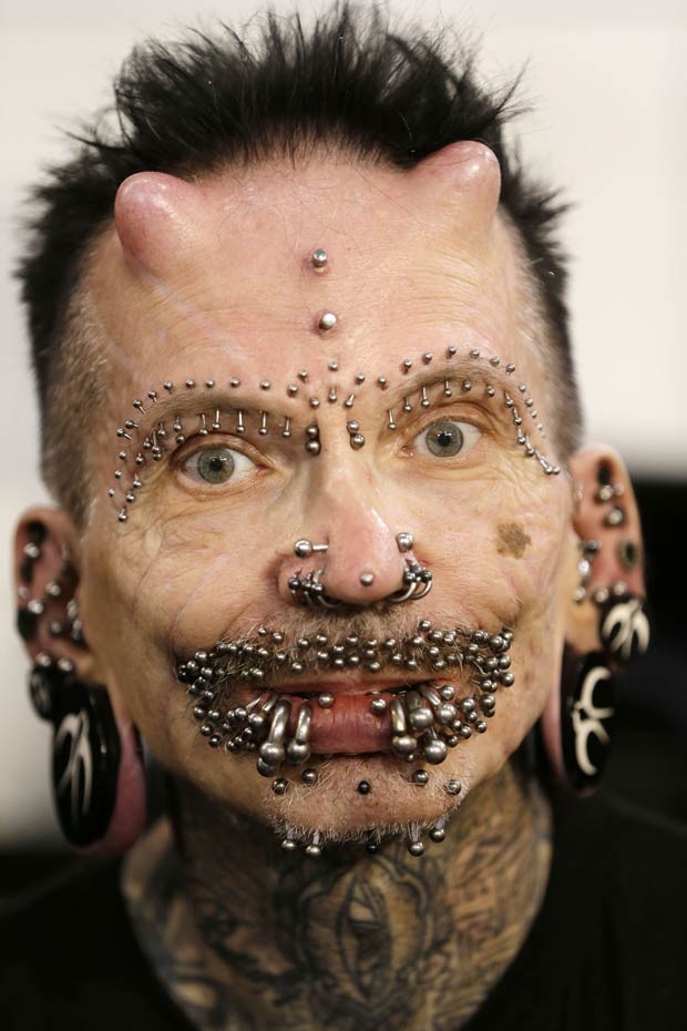 Na testa, Rolf Buchholz tem implantes que lembram chifres e um piercing entre eles (Foto: Thanassis Stavrakis/AP) greece-tattoo-convent fran-