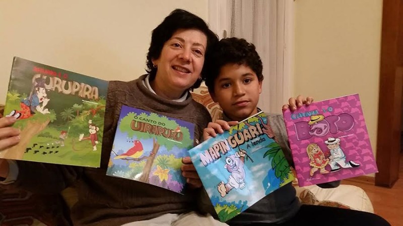 Uma professora de língua portuguesa que reside na Bélgica exibe os livros de Enilson Amorim, adquiridos para seu afilhado