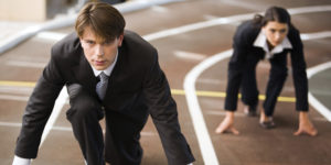 Businessman and businesswoman lined up getting ready for race in business