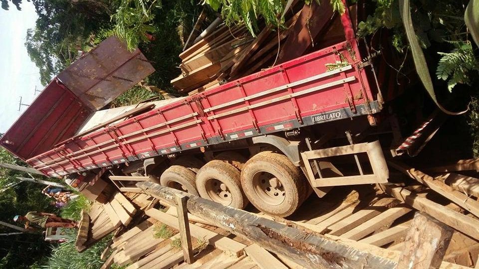Carreta carregada de madeira cai na ponte do Igarapé Catiano, em Sena Madureira