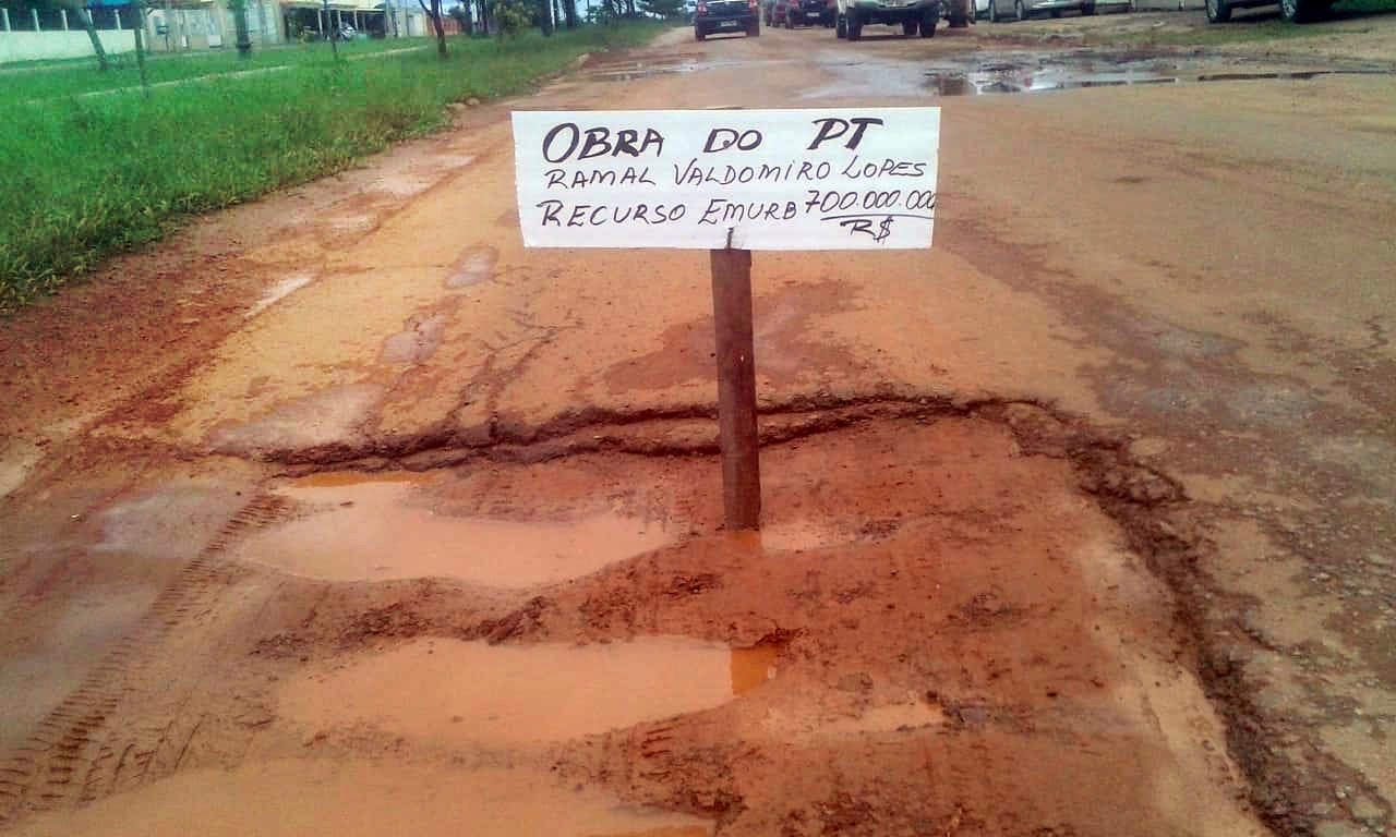 Com placa dentro de buraco, moradores comparam uma das principais ruas de Rio Branco com ramal