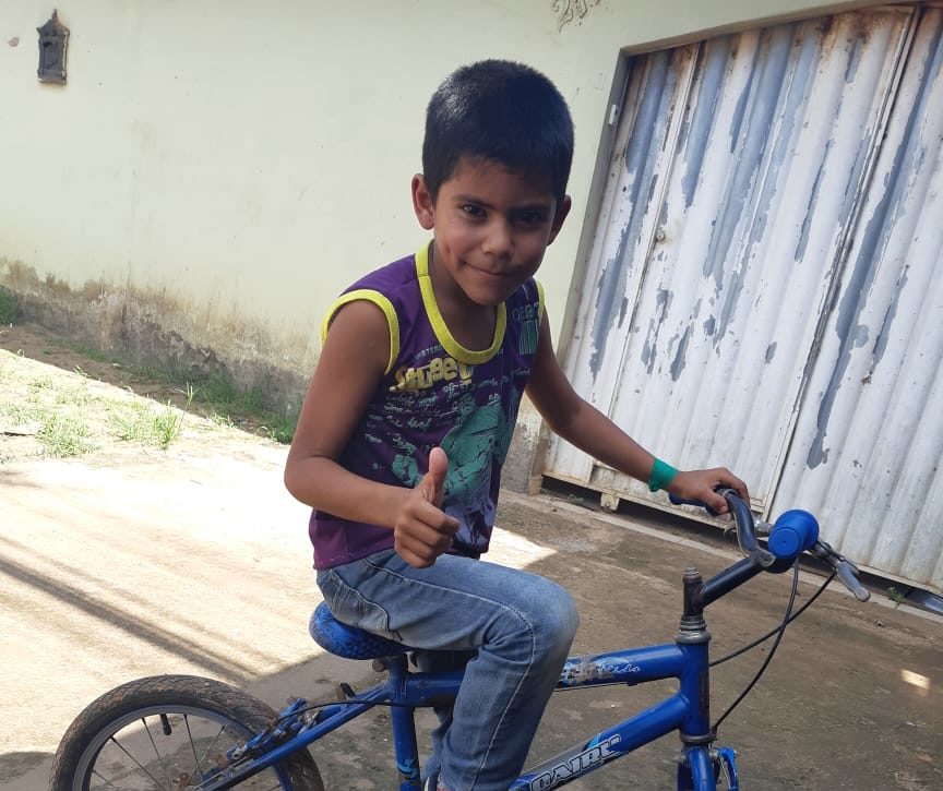 Criança que ia a pé para escola ganha bicicleta de funcionários de peixaria na Vila Acre