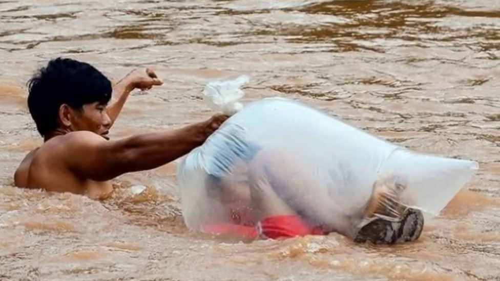 Pais embalam crianças em sacos plásticos para atravessar rio e ir a escola