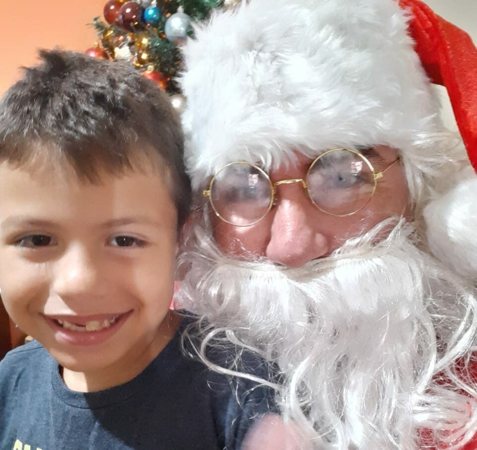 Ao lado do filho, pai se veste de Papai Noel para animar pessoas no centro de Rio Branco