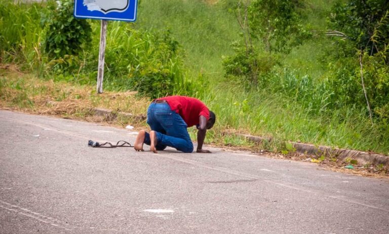 Imigrante que tenta atravessar fronteira no AC reza ajoelhado na BR-364