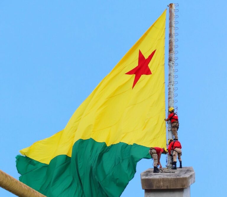 Bombeiros e a bandeira do Acre na ponte sobre o Rio Juruá