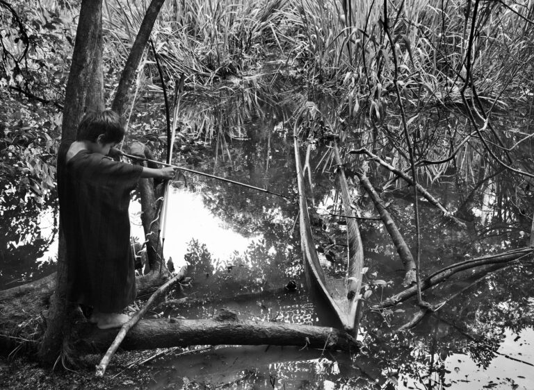 Criança ashaninka se preparando para fisgar peixe no Acre