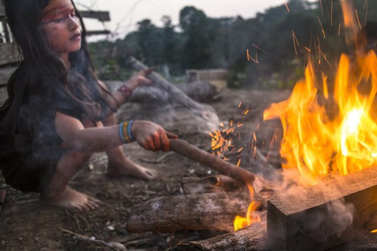 Criança indígena fazendo fogueira no interior do Acre