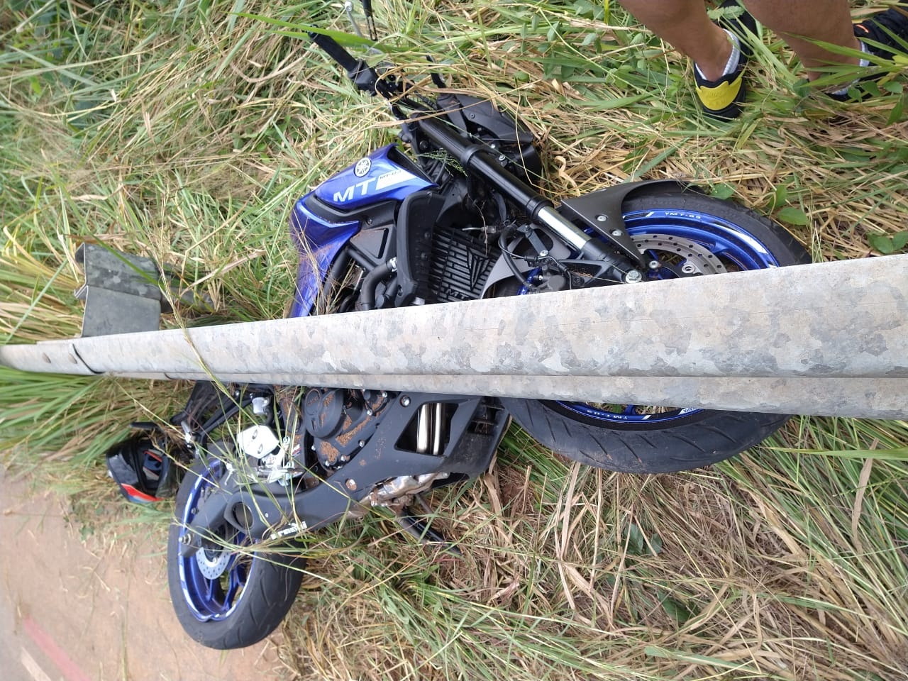 Motociclista perde controle e bate em mureta após máquina do Deracre espalhar óleo na pista