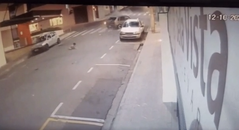 Menino é jogado para fora de carro em batida e quase é atropelado por ônibus; vídeo