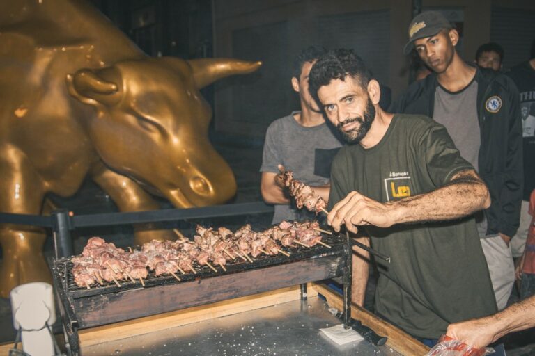 ONG faz churrasco para moradores de rua em frente a Touro de Ouro da Bolsa de Valores, no Centro de SP