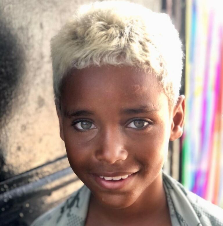 Menino da Cidade de Deus viraliza após foto em portão de ONG e entra para agência de modelos
