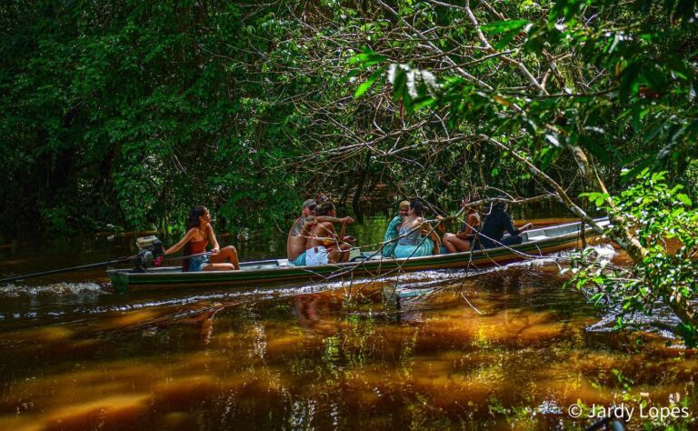Mulher conduzindo barco no Rio Crôa