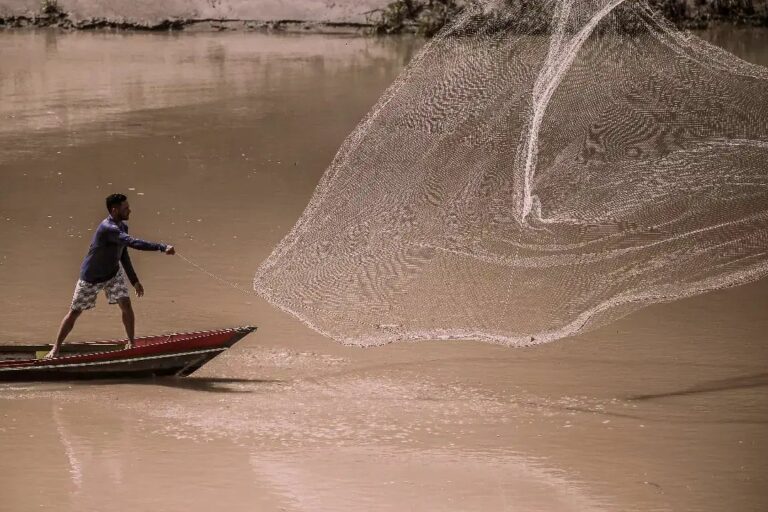 Homem lançando tarrafa no Juruá