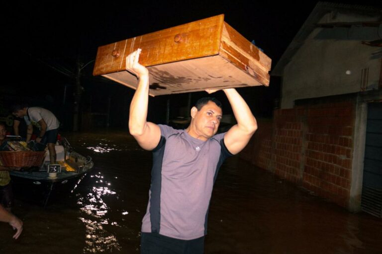 Deputado entra na água e ajuda no transporte de objetos dos alagados