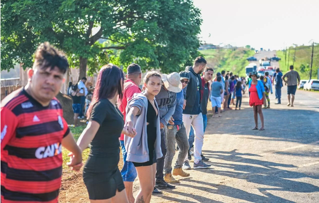 Moradores de invasão fazem corrente humana para impedir acesso de policiais