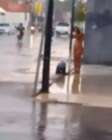 VÍDEO: mulher é flagrada tomando banho sem roupa na rua durante chuva na capital