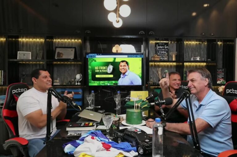 Bittar e Ulysses presenteiam Bolsonaro com bolo de aniversário durante participação em podcast