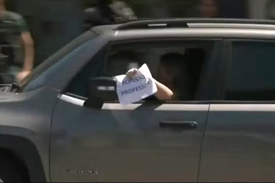 com-medo-de-tiro,-mulher-exibe-cartaz-de-“professora”-em-acao-policial