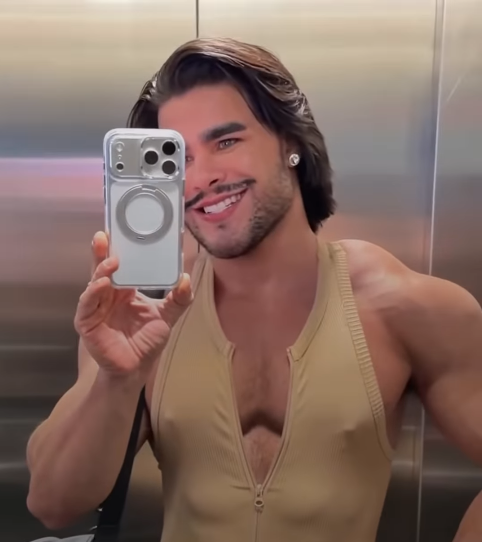 Homem treinando na academia com macacão fitness masculino, tendência de 2026.