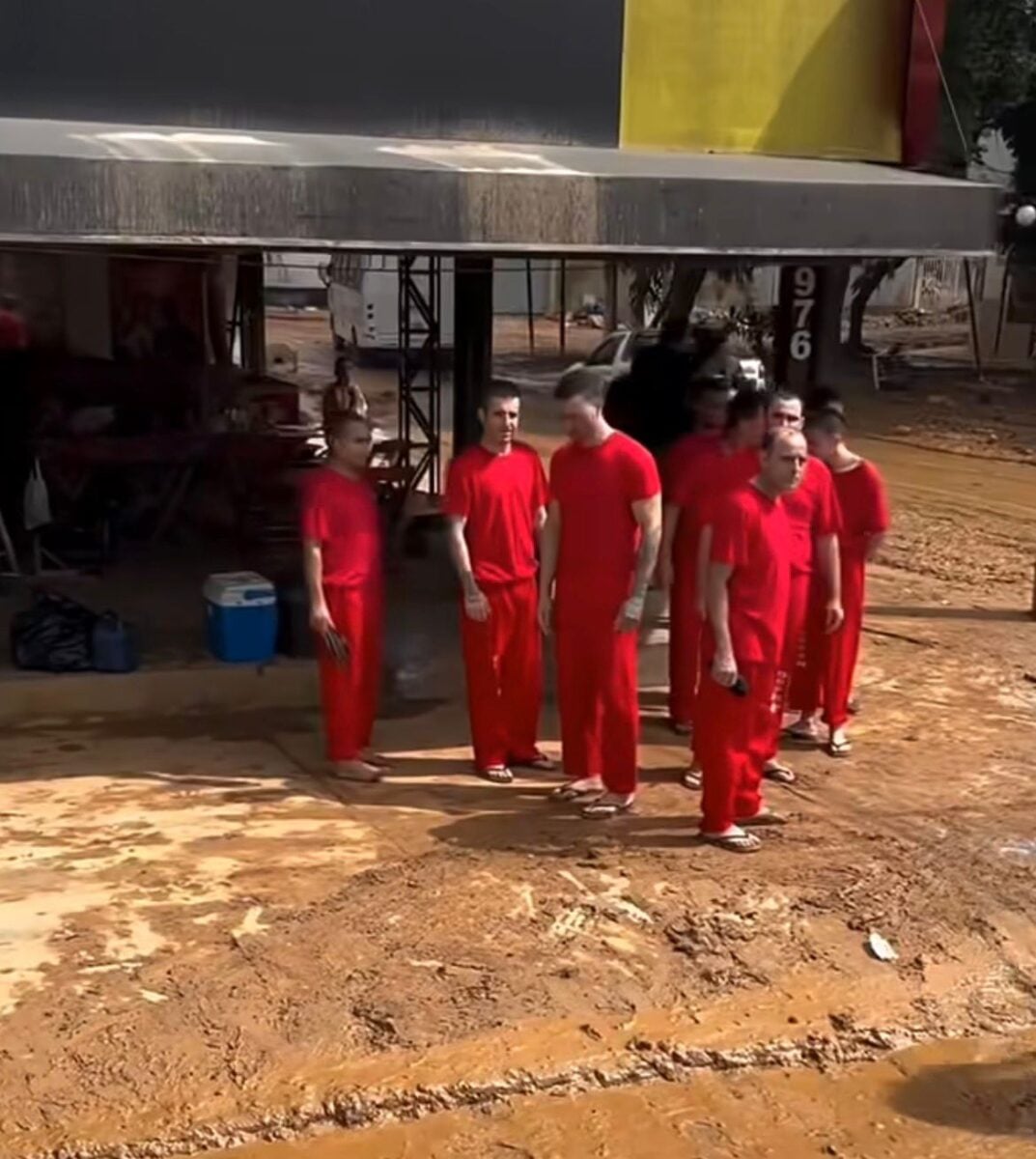 Onze detentos foram mobilizados para ajudar na limpeza após chuvas deixarem ruas com lama e entulho. Trabalho ocorre com fiscalização de policiais penais.