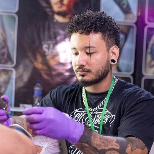 No vídeo, o criador narra o início precoce do artista na tatuagem e a decisão de deixar o Acre para buscar crescimento em Palhoça, em Santa Catarina