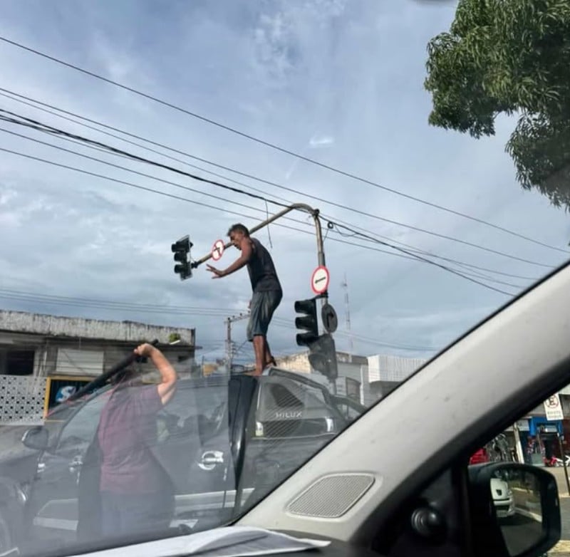Homem sobe no teto de caminhonete e chama atenção em semáforo no centro de Rio Branco.
