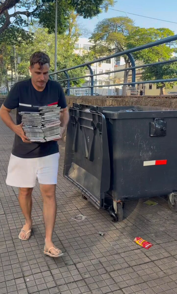 Homem entra em lixeira para resgatar coleção de CDs descartados