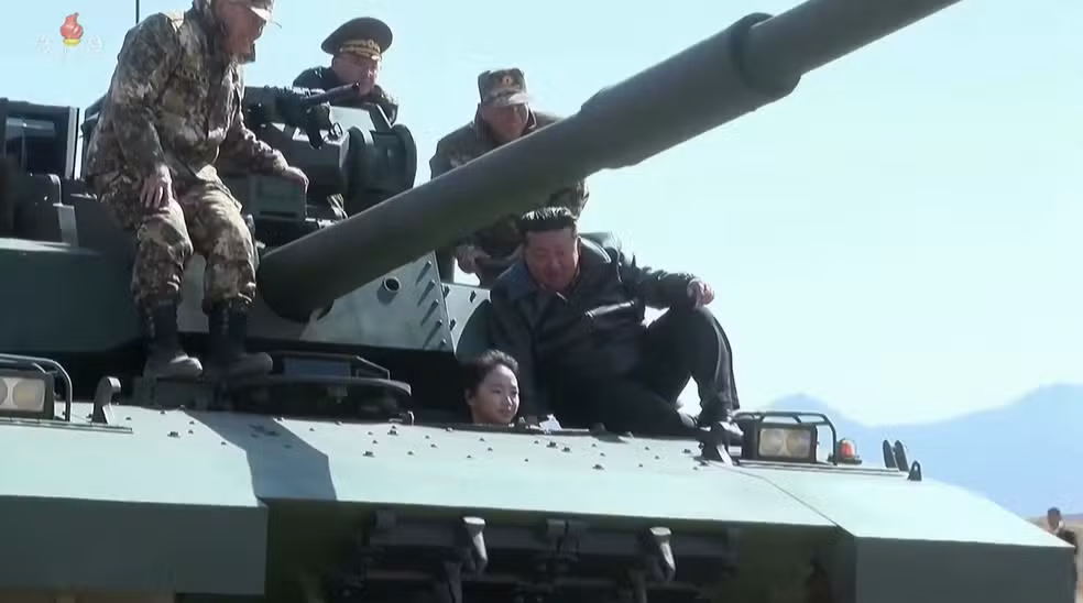 O regime da Coreia do Norte divulgou, nesta sexta-feira (20/03), imagens que reforçam os rumores sobre o futuro político do país. O líder Kim Jong-un foi filmado participando de manobras militares a bordo de um tanque de guerra, mas o que realmente chamou a atenção foi a presença de sua filha, Kim Ju-ae, de aproximadamente 13 anos, ao seu lado durante o exercício.