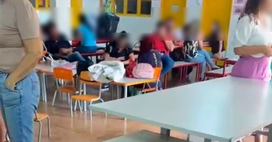 Professor joga carteiras contra três estudantes em sala de aula Professor joga carteiras contra três estudantes em sala de aula