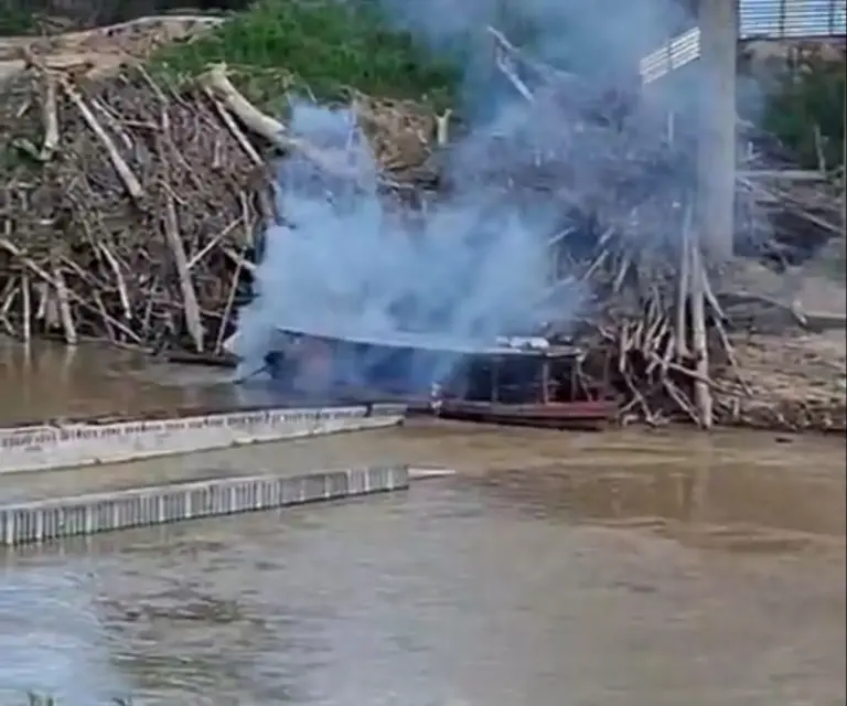 Ribeirinho tenta passar com barco por cima dos escombros de ponte que caiu